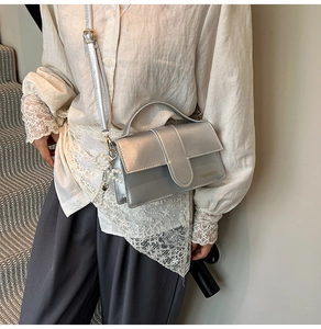 Close-up of silver mini square bag with metallic texture and pearl charm detail