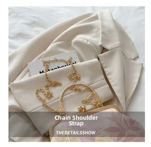 Detail showing the floral jacquard fabric and golden chain strap of the shell bag