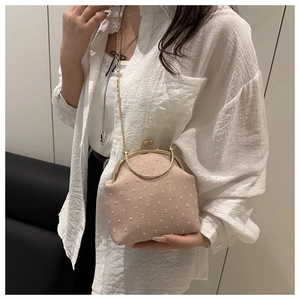 Modèle portant un sac bandoulière en jacquard rose avec chaîne et fermoir dorés