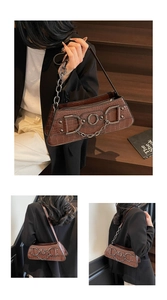 Detail of vintage brown crocodile embossed armpit bag with silver metal chain decor