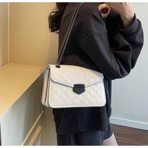 Vue latérale du sac bandoulière matelassé blanc avec fermoir en métal noir porté