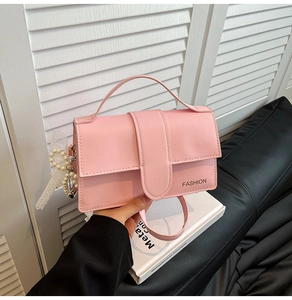Detailed view of pink PU leather handbag with elegant pearl and lace charm accessories