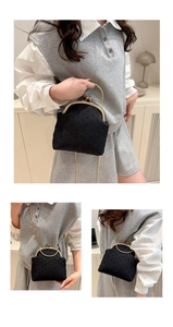 Detalle del bolso kiss-lock negro con tela de lunares y asa de metal dorado fino