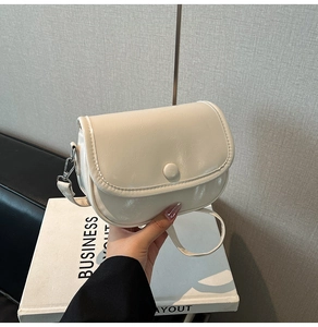 Close-up of the smooth beige PU leather texture and silver metal hardware on a crossbody bag