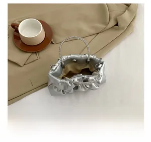 Silver pleated cloud bag showing inner capacity with rhinestone handle detail