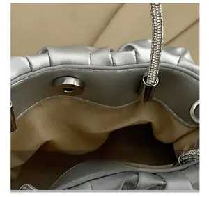 Detail view of the silver pleated handbag showing internal magnetic snap button closure