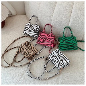 Various zebra print mini crossbody bags in multiple colors shown on a textured white surface