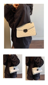 Détail du sac en cuir matelassé blanc avec chaîne argentée et fermoir en métal noir unique
