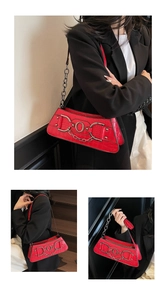 Detail showing the red faux crocodile texture and metallic ring chain on the shoulder bag