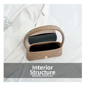 Top view of woven brown handbag showing interior compartment and sleek flap closure