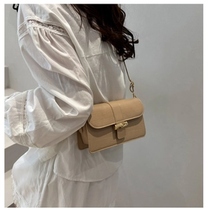 Detail of beige faux crocodile leather shoulder bag with vintage bamboo-style gold clasp