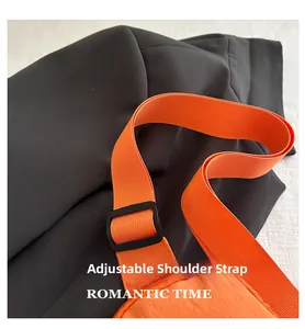 Détail de la sangle orange réglable avec boucle noire pour sac bandoulière minimaliste