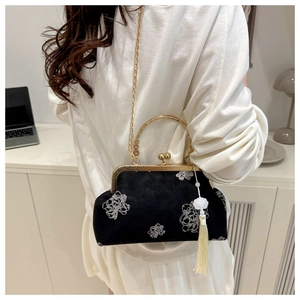 Detailed back view of a black suede bag with white peony embroidery and gold chain strap
