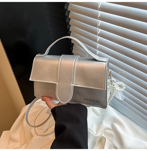 Detail of silver glitter crossbody bag with pearl lace charm and fashion text print