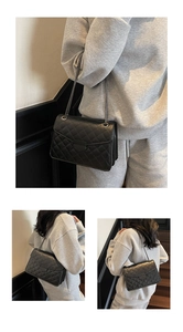 Détail du sac bandoulière en cuir matelassé noir montrant la texture et la chaîne