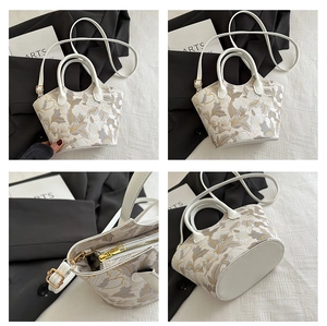 Detail view of iris flower print handbag with golden hardware and adjustable strap