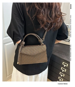 Vue détaillée du sac bandoulière avec motif monogramme porté par un mannequin femme