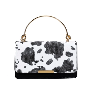 Elegante bolso bandolera con estampado de vaca y asa de metal dorada para mujer