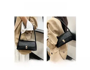 Detail of black woven texture bag featuring a secure gold lock clasp and versatile straps