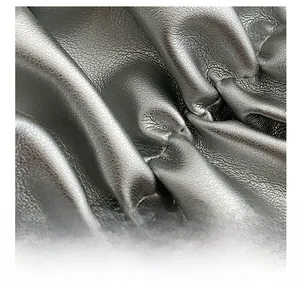 Close-up of black leather texture with fine stitching and soft pleated folds detail