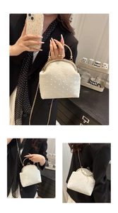 Detalle de bolso vintage blanco con textura de lunares 3D y cadena dorada