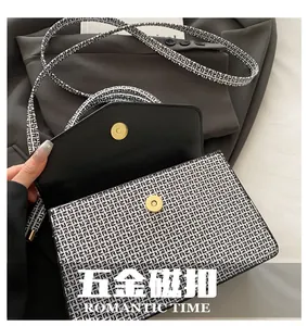 Détail des fermoirs magnétiques dorés sur un sac bandoulière à motifs en simili cuir