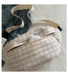 Close-up of beige plaid waist bag with flower embroidery and adjustable strap