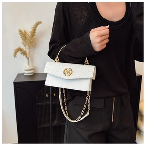 Detail of white leather handbag featuring woven texture flap and golden M logo hardware