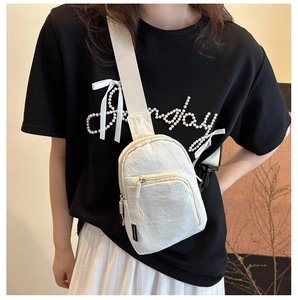 Détail d'un sac de poitrine en nylon blanc avec fermeture éclair et cordon de serrage