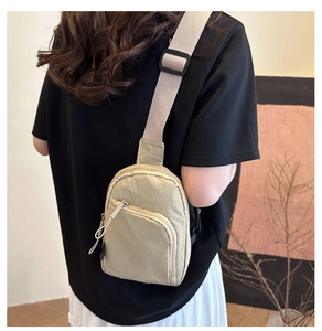 Dettaglio borsa a tracolla in nylon beige con cinturino regolabile e finitura testurizzata