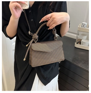 Vue détaillée du petit sac carré à motif vintage avec poignée cylindrique et anneaux en métal