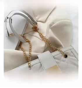 Close-up of beige quilted bag with golden chain strap and luxury metal push-lock
