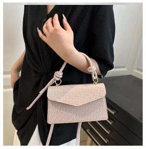 Détail du sac à rabat monogramme avec poignée nouée et anneaux métalliques dorés