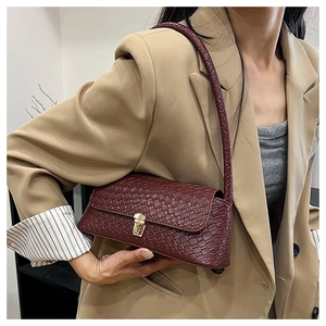 Detail of burgundy woven texture shoulder bag with gold square buckle on khaki blazer