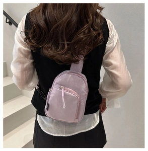 Détail d'un sac de poitrine en nylon lavande montrant le style croisé et la texture