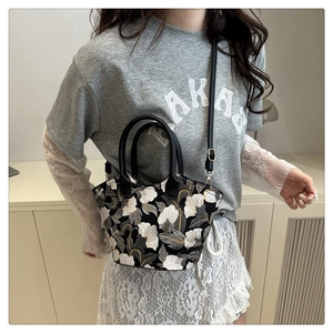 Fashionable model carrying a floral pattern crossbody bag with leather shoulder straps
