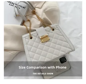 Quilted white handbag with gold chain strap shown alongside a phone for size comparison
