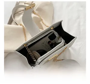 Macro view of white leather bag interior showing capacity for phone and cosmetics