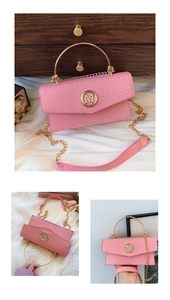 Detail of pink flap bag featuring crocodile texture, gold M logo and ring handle