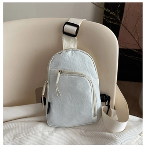 Détail de sac de poitrine gris avec bandoulière réglable et poche avant zippée