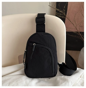 Vue détaillée du sac bandoulière en nylon noir avec texture plissée et poche zippée