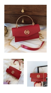 Detail of red snake-pattern flap bag featuring round gold handle and M logo hardware