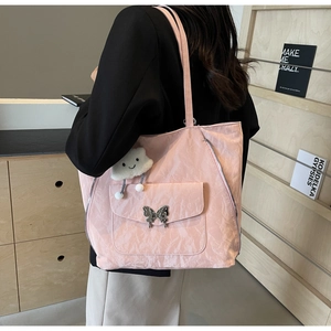 Detail of pink pleated tote bag with silver butterfly buckle and cloud charm on model