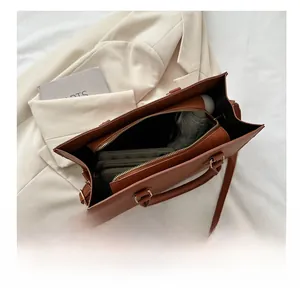 Interior view of brown leather tote showing capacity for umbrella, phone, and wallet