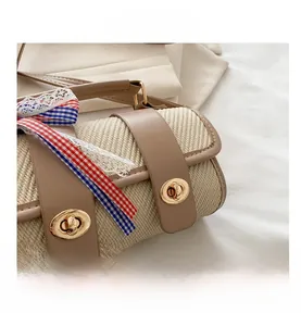 Detail of straw woven pillow bag featuring leather straps, lace trim and golden twist locks