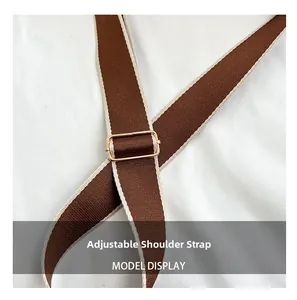 Detail of adjustable brown canvas shoulder strap with gold metal buckle for saddle bag
