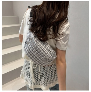 Detail showing grey gingham chest bag with floral embroidery and adjustable strap