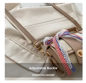 Detail of adjustable shoulder strap buckle on woven crossbody bag with silk ribbon decoration