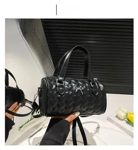 Detalle de bolso Boston negro con acolchado de corazón y lazo metálico