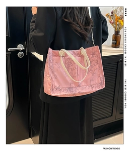 Pink tote bag with bamboo leaf pattern showing shoulder carry strap detail